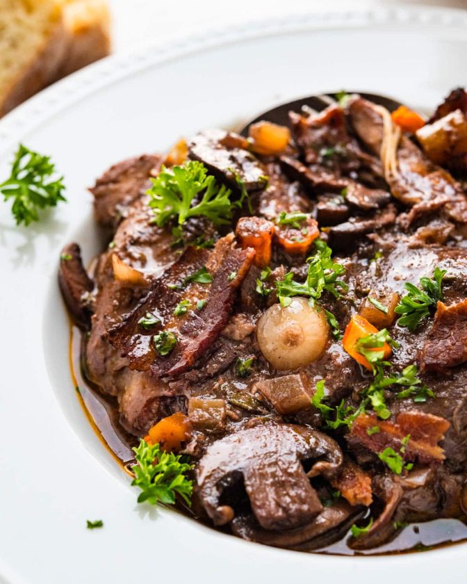 Coq au Vin: A slow-cooked chicken dish in red wine with mushrooms and onions.